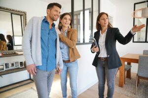 A family packing household items into cardboard boxes in a sunny, well-lit living room.
